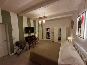 ein Wohnzimmer mit einem Bett, einem Tisch und einem Schreibtisch in der Unterkunft Sidus Rooms in Sona