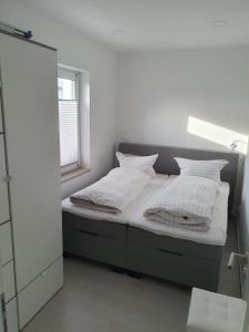 una camera da letto con un letto con lenzuola bianche e una finestra di ***FeWo Am Achterwasser *** a Lütow