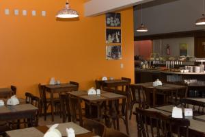 a dining room with wooden tables and chairs at Hotel Açoriano in Penha