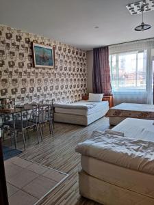 a room with two beds and a table and chairs at PLEVEN Rooms in Pleven +35 photos
