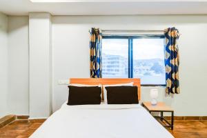 a bedroom with a large bed with a window at Super Collection O Malkajgiri in Hyderabad