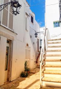 una scala che porta a un edificio con pareti bianche di Casa Antica Cibbun a Martina Franca