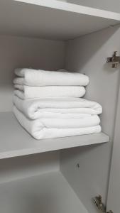 una pila di asciugamani bianchi su una mensola in bagno di Джамбула 177 a Kökşetaw