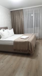 una camera da letto con un letto grande con cuscini bianchi di Джамбула 177 a Kökşetaw