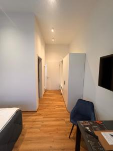 a room with a bed and a chair and a table at Sweet Hotel Da Giovanni in Gladenbach
