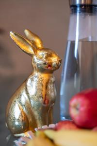 una statua di un coniglio su un tavolo con mele di Special ROGER F RABBIT 1 Apartment, Roche Towers, 10-STAR a Basilea Altre 37 foto