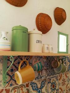 una mensola con pentole, padelle e altri prodotti da cucina di Casa Antica Cibbun a Martina Franca