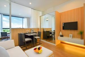 a living room with a couch and a dining room at Condo Near Bangtao Muay Thai & MMA in Ban Thalat Choeng Thale +8 photos