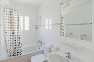 Un baño blanco con lavabo y ducha. en Apartamentos Timon - Emar Hotels, en Es Pujols 19 fotos más