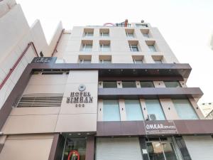 a building with a sign for the hotel sharjah at Super Collection O Simran Raghuveer Para in Rajkot