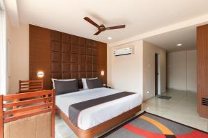 a bedroom with a large bed and a ceiling fan at Super Collection O Simran Raghuveer Para in Rajkot