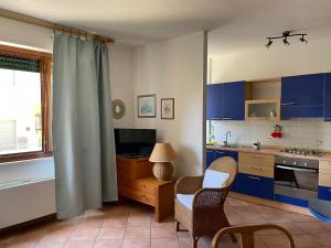 a kitchen with blue cabinets and a table and chairs at Casa Roberta in Alghero