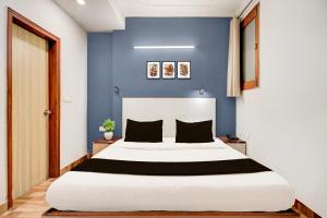 a bedroom with a large bed with a blue wall at Super Collection O Sector 20 Noida in Noida +24 photos