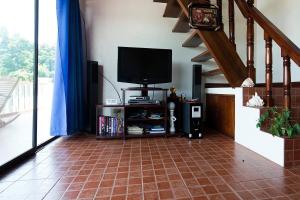 a living room with a television and a tiled floor at RELAX White house, Puerto Galera in Puerto Galera