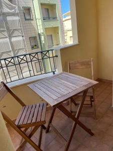 a wooden table and two chairs on a balcony at Casa Roberta in Alghero