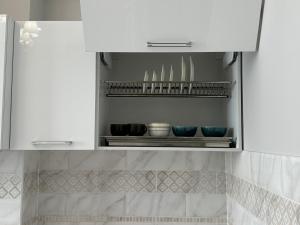 a kitchen cabinet with some bowls and plates in it at Lovely house in the city center in Bishkek