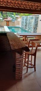 - une table et une chaise sur une terrasse avec piscine dans l'établissement Ap Classic - Pousada Flor da Serra - Mulungu, à Mulungu