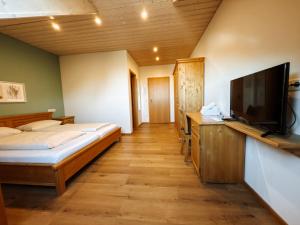 a bedroom with a bed and a flat screen tv at Gasthof Janser in Altenstadt