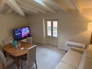a living room with a table and a tv at Germano Reale in Iseo
