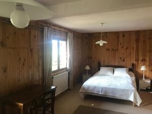 Un dormitorio con una cama y un escritorio y una ventana. en Chalet spacieux et ensoleillé à Montgenèvre - 10 pers - 5 chambres - Quartier calme et résidentiel - FR-1-445-139, en Montgenèvre