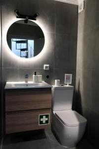 a bathroom with a toilet and a sink with a mirror at Home Santa Clara in Albufeira