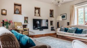 a living room with a couch and a tv at Lavish Tudor Estate & Gardens - Sleeps 20 in Hales +51 photos