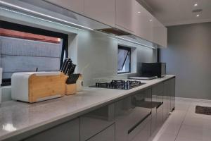 a kitchen with a stove and a counter top at Exquisite Family Cape Villa Pool and Fire Pitt in Cape Town