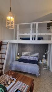 a bedroom with a white bunk bed and a table at In Parva Domus - Cute and Central Mini Suite Apt in Bitonto