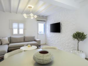 a white living room with a table and a couch at Plateia House Mykonos in Mikonos