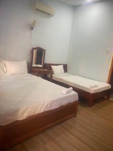 a bedroom with two beds and a mirror in it at Thành Khôi Bungalow in Phú Quốc