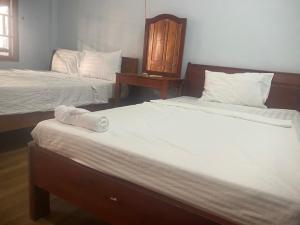 a room with two beds and a table at Thành Khôi Bungalow in Phú Quốc