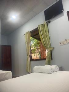 a bedroom with a bed and a window with curtains at Thành Khôi Bungalow in Phú Quốc