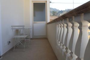 a balcony with a door and a table and a stool at MariSte Apartment in Parghelia