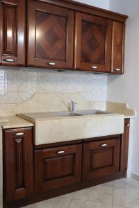a kitchen with a sink and wooden cabinets at MariSte Apartment in Parghelia +48 photos