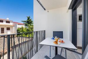 einen weißen Tisch auf dem Balkon eines Gebäudes in der Unterkunft Luxury Studio Rim Tim in Malinska