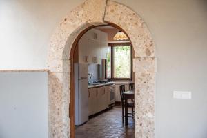 an archway in a kitchen with a table and a refrigerator at Casa Ciclope in Arpino