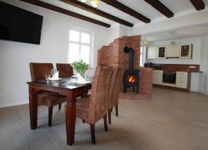 a dining room with a table and a fireplace at Landhaus Boddenhus in Polchow