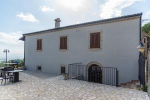 a white building with a courtyard with a table at Casa Ciclope in Arpino