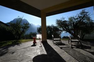 two chairs on a porch with a view of mountains at IseoLakeRental - Villa Retrò in Riva di Solto