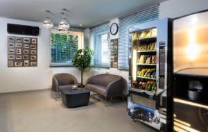 a room with two chairs and a drink refrigerator at Automobil Hotel in Kraków