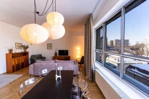 Una sala de estar con una mesa y una gran ventana. en Rezident Eminescu, en Bucarest