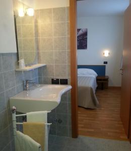 La salle de bains est pourvue d'une baignoire, d'un lavabo et d'un lit. dans l'établissement Risorgimento - Albergo - Bar, à Morciano di Romagna