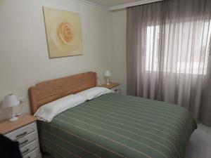 un dormitorio con una cama y una ventana en Cristel, en Puentecesures