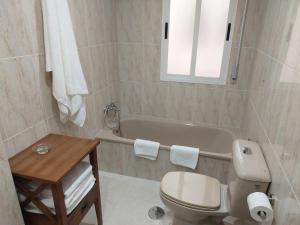 a bathroom with a toilet and a bath tub at Cristel in Puentecesures +25 photos