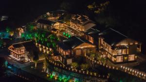 un grande edificio illuminato di notte di Ethnic Hundred-years Elysian Culture&Art Scholar Resorts a Zhangjiajie