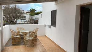 a patio with chairs and a table on a balcony at Casa Elenita in La Oliva