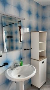 a bathroom with a white sink and a mirror at Casa Elenita in La Oliva