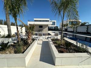 a house with a swimming pool and palm trees at Infinity Villa in Rrushkull