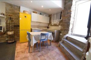 a kitchen with a table and chairs and a yellow refrigerator at Nuraghe di mare in La Maddalena +15 photos
