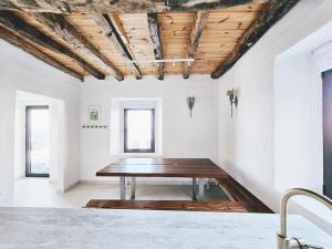 a table in a room with white walls and wooden ceilings at Stone Villa at the Vrelo in Dobra Voda
